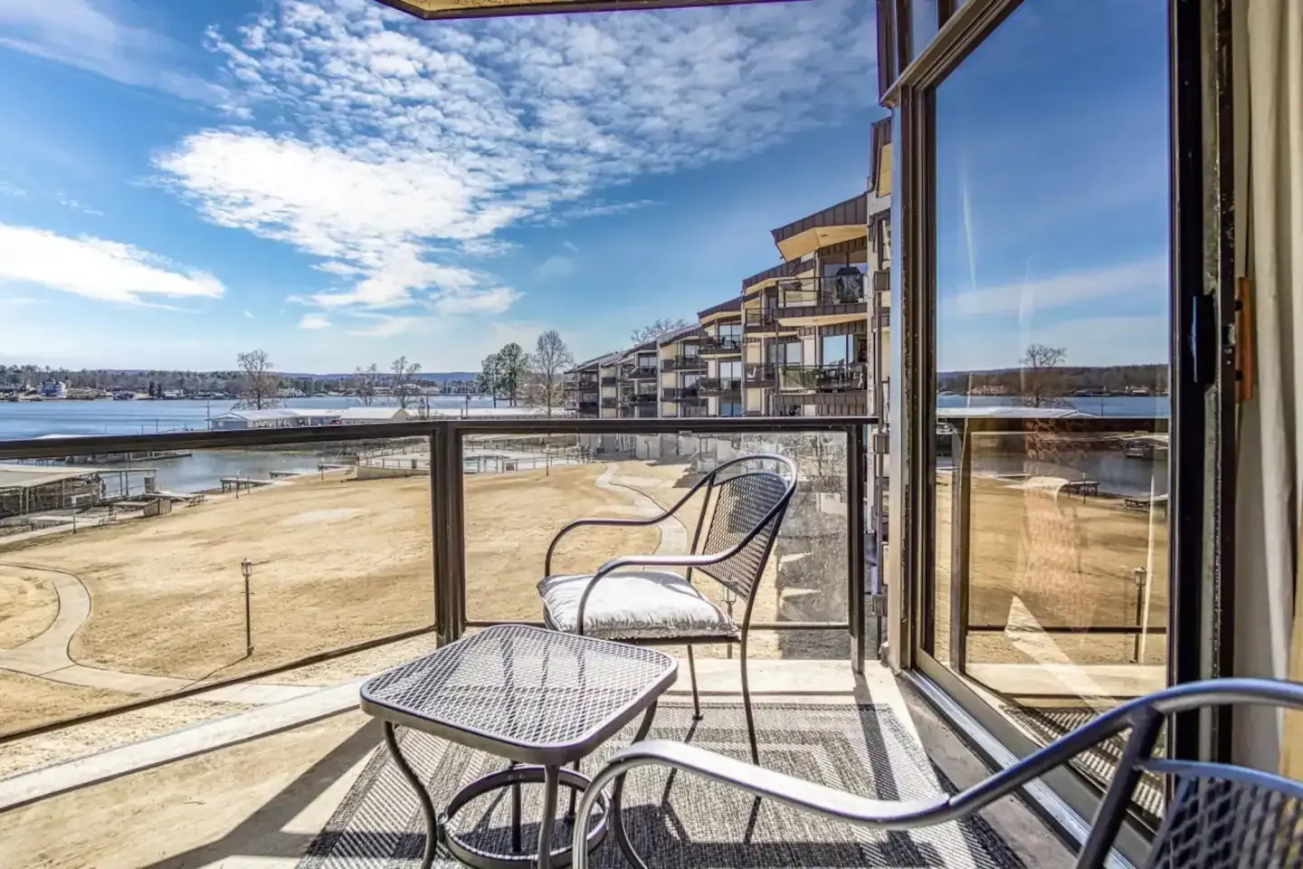 A balcony with a table and chairs overlooking a body of water.