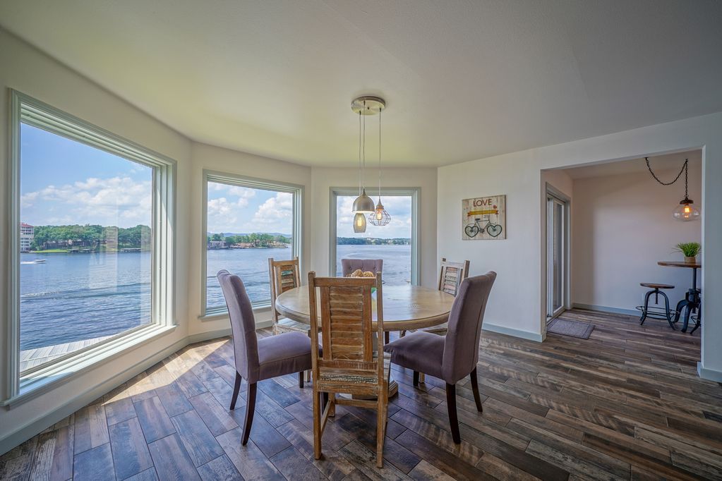 A dining room with a table and chairs and a view of the water.