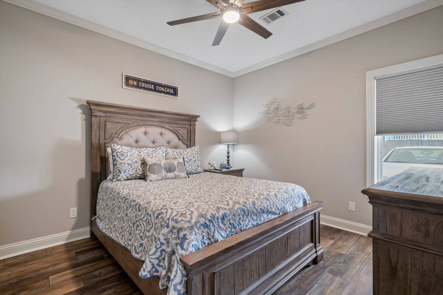 A bedroom with a king size bed and a ceiling fan.
