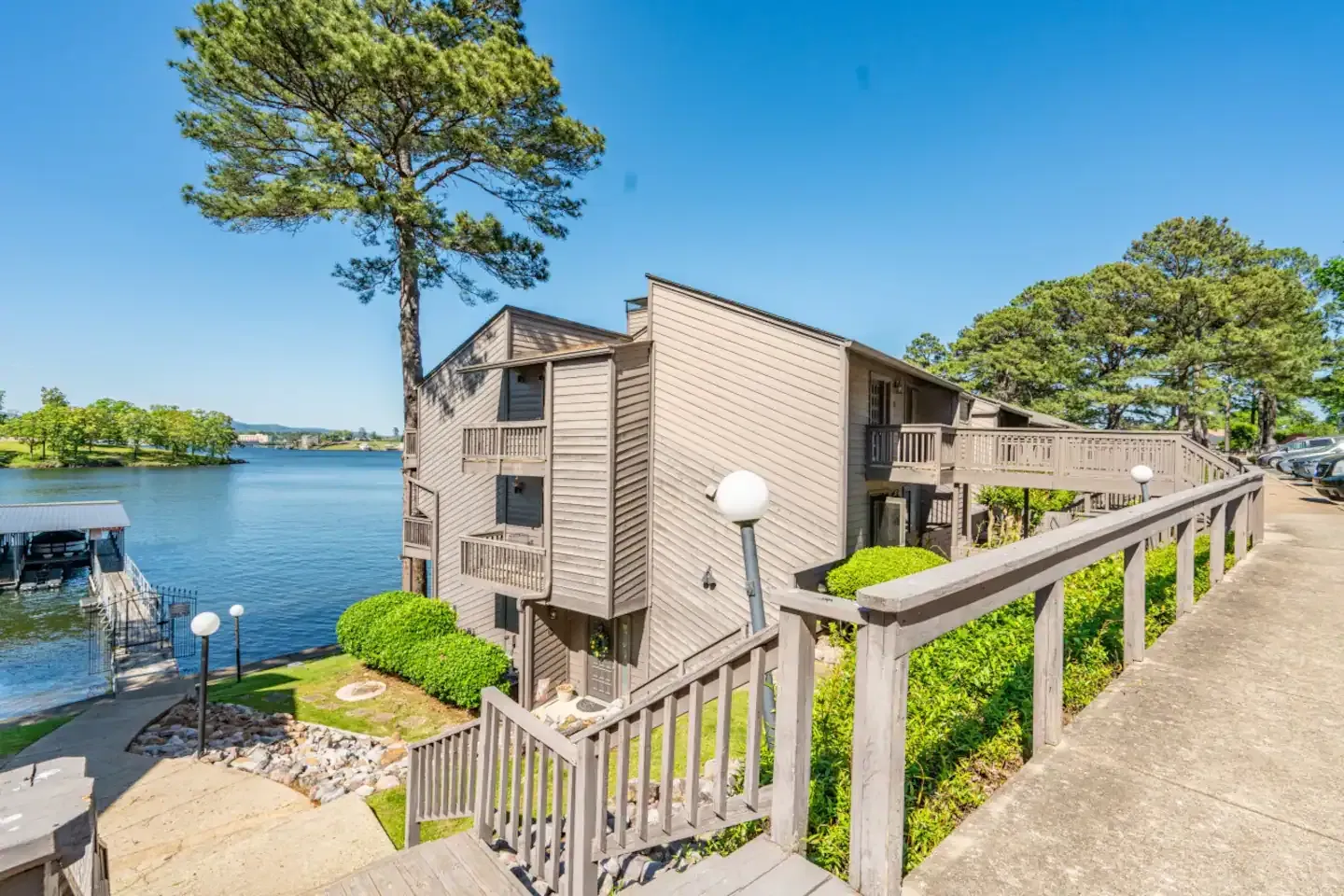 A house with stairs leading up to it next to a lake.