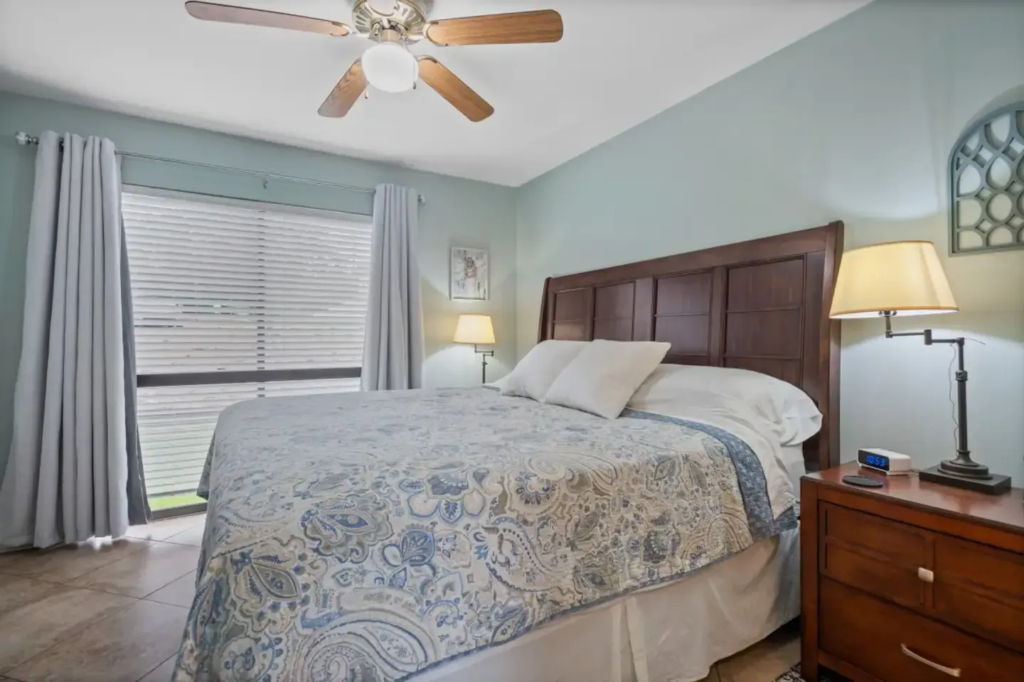 A bedroom with a king size bed and a ceiling fan.