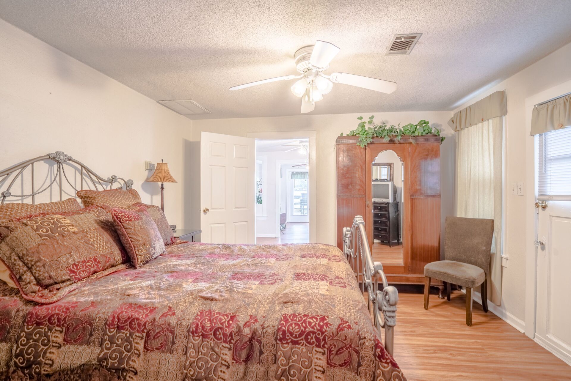 A bedroom with a king size bed and a ceiling fan.
