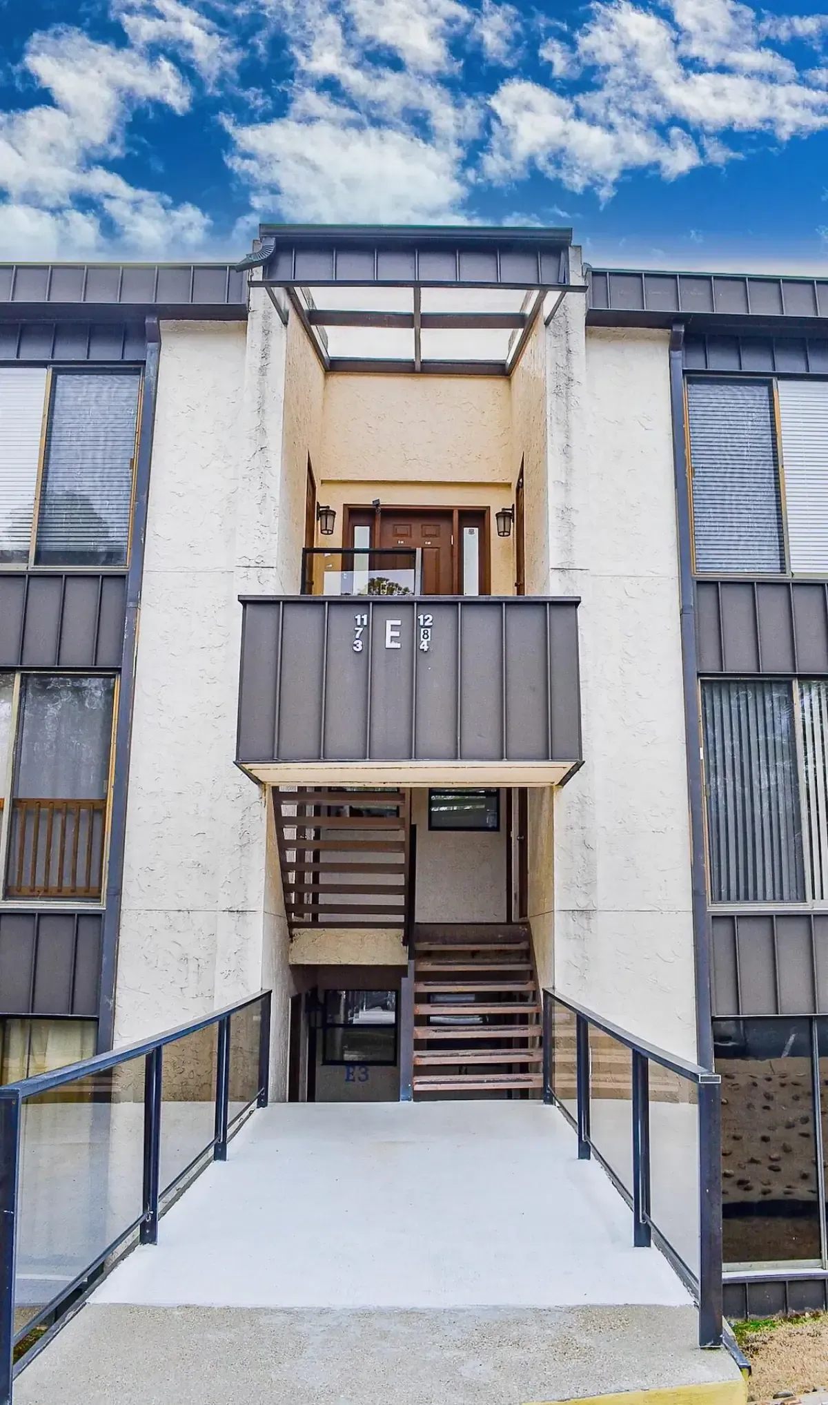 A large apartment building with stairs leading up to the second floor.