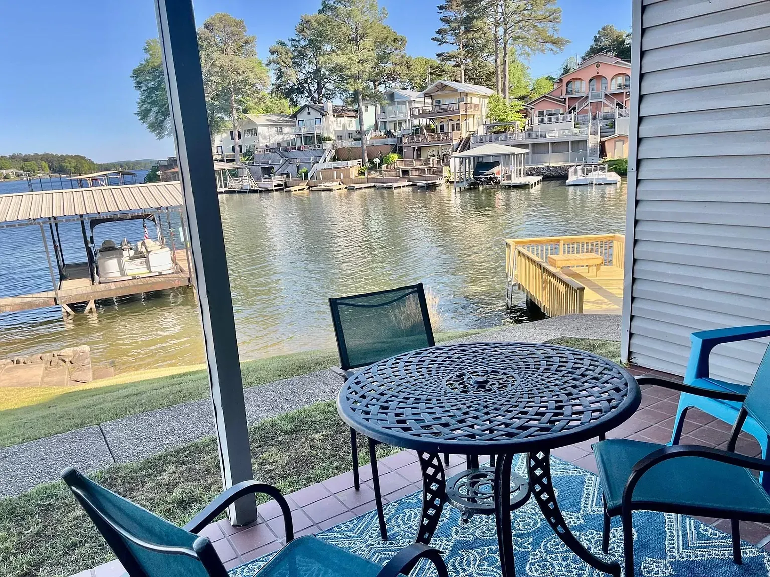 A patio with a table and chairs overlooking a lake.
