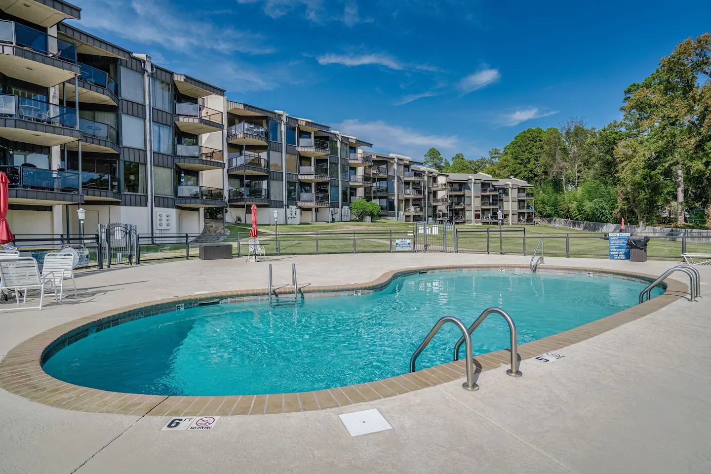 There is a large swimming pool in front of a building.