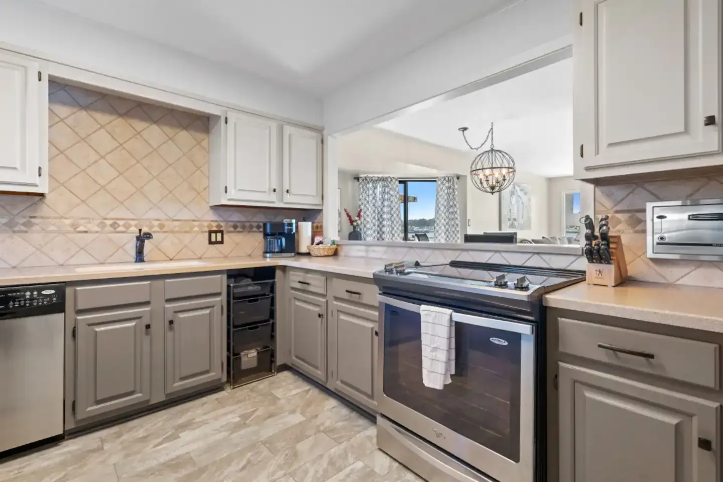 A kitchen with stainless steel appliances and gray cabinets.