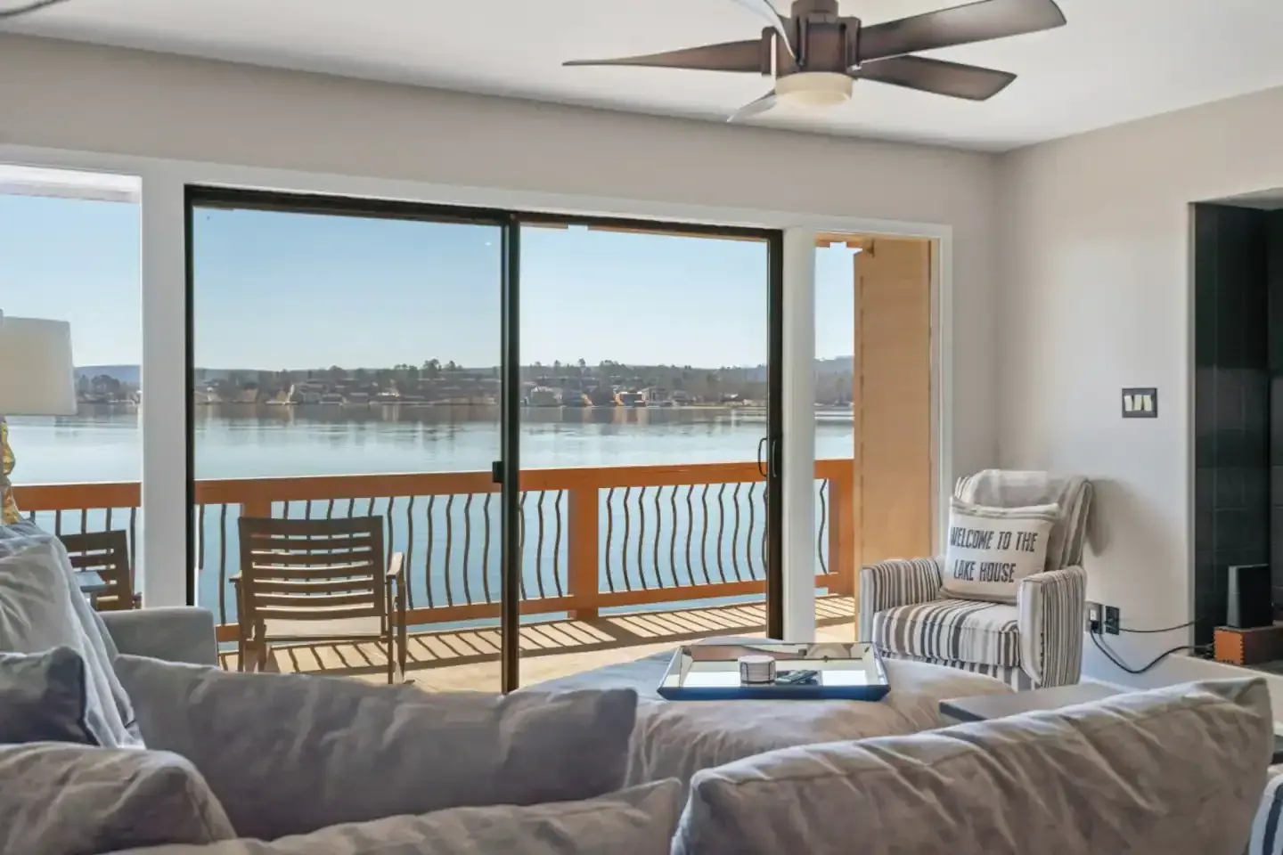 A living room with a view of a lake and a ceiling fan.