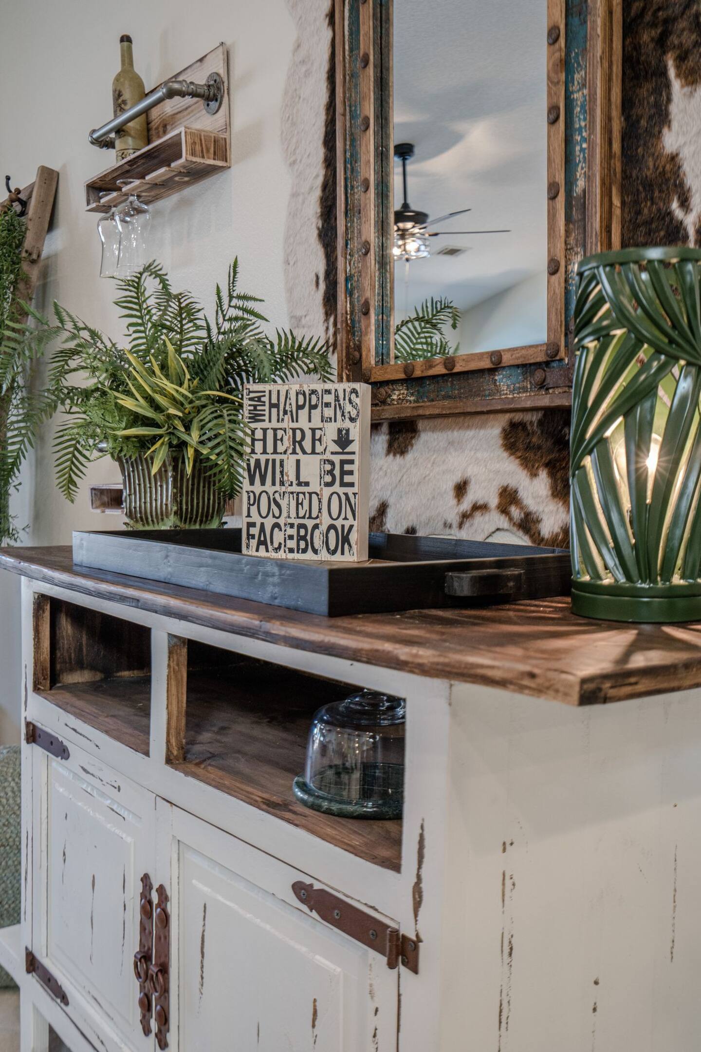 A white dresser with a sign on top of it and a mirror.