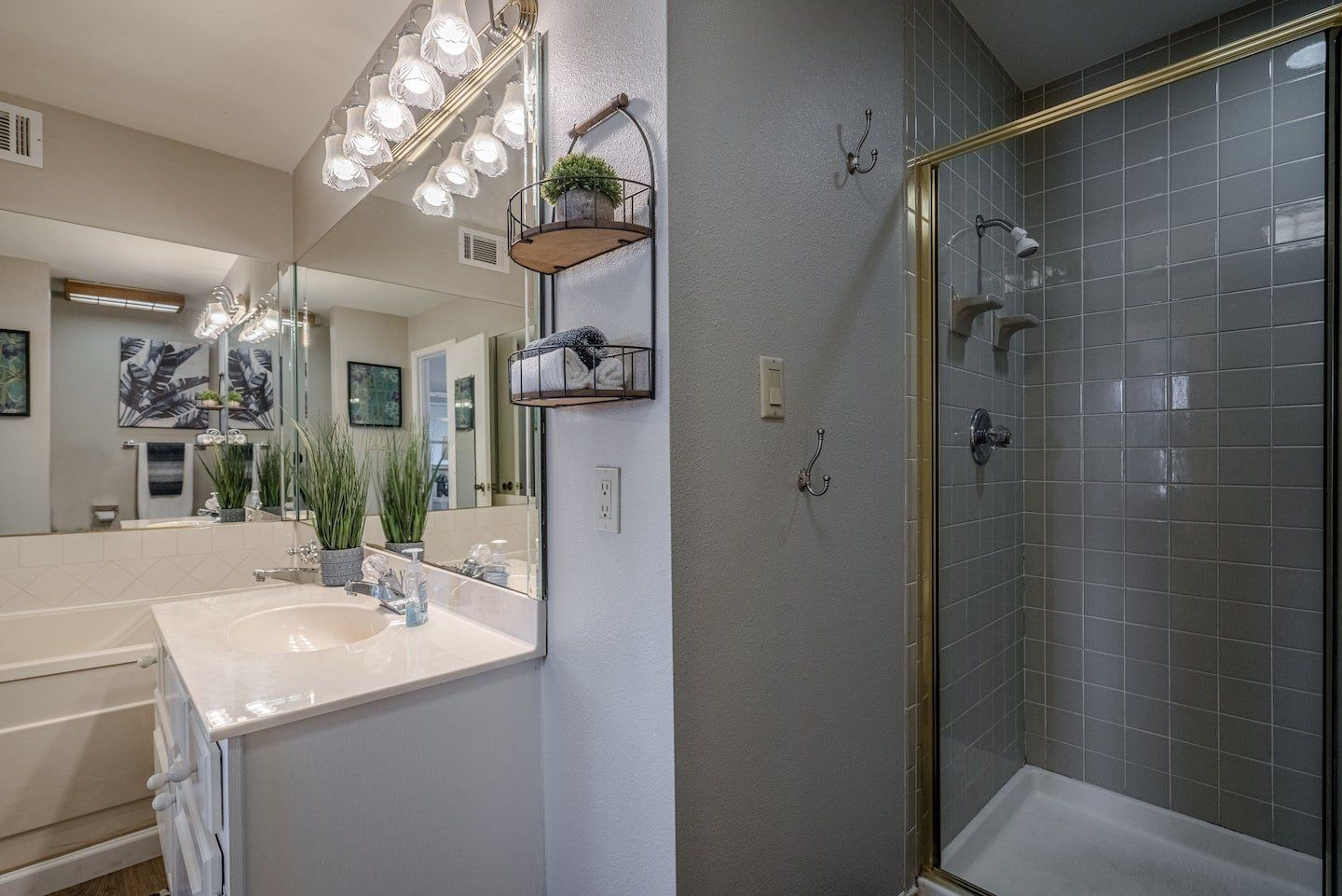 A bathroom with a sink , toilet , shower and mirror.