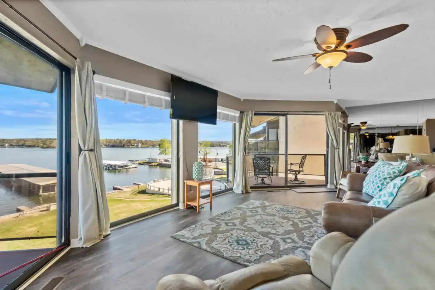 A living room with a ceiling fan and a view of a lake.