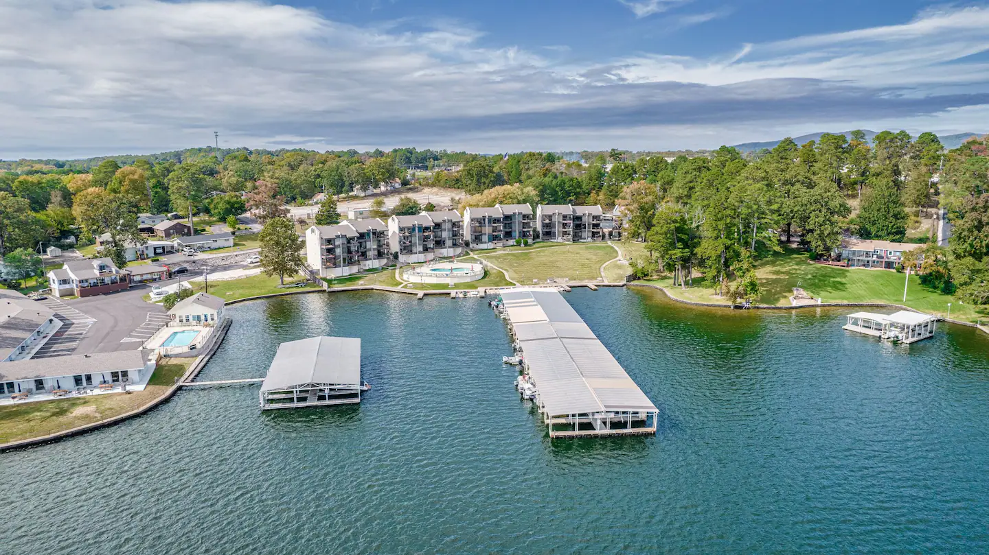 An aerial view of a large body of water with a dock and a building in the background.