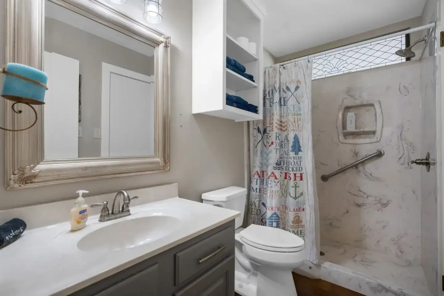 A bathroom with a toilet , sink , mirror and shower.