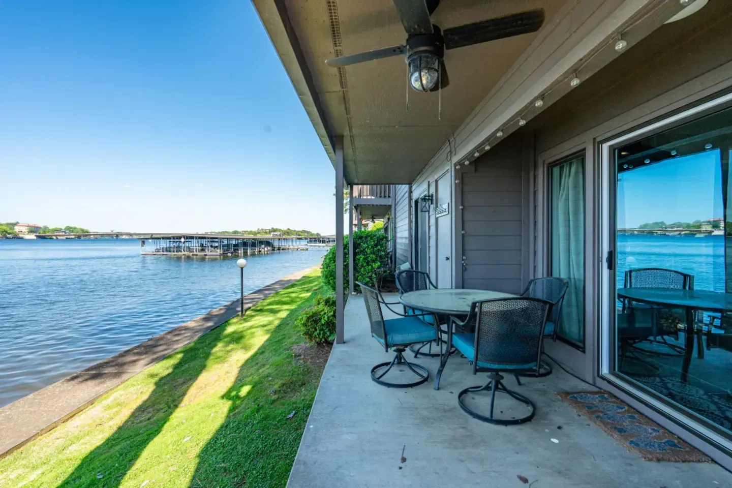 A patio with a table and chairs overlooking a body of water.