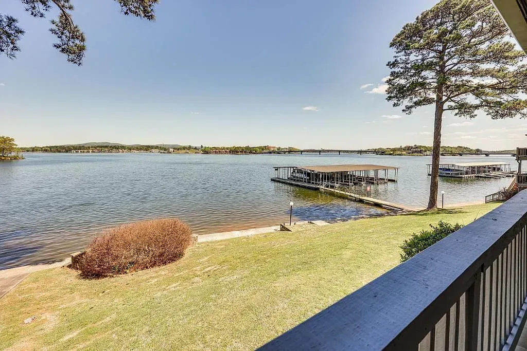 A view of a lake from a balcony with a dock in the background