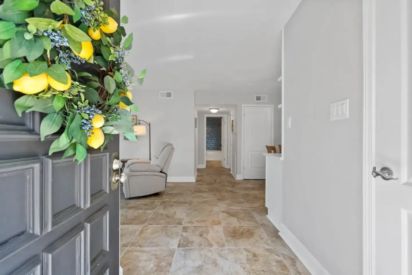 A black door with a wreath of lemons on it.