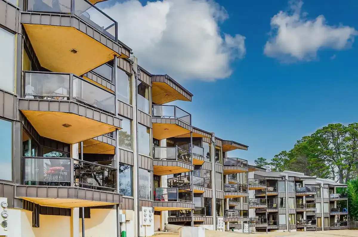 A large apartment building with lots of balconies on a sunny day.