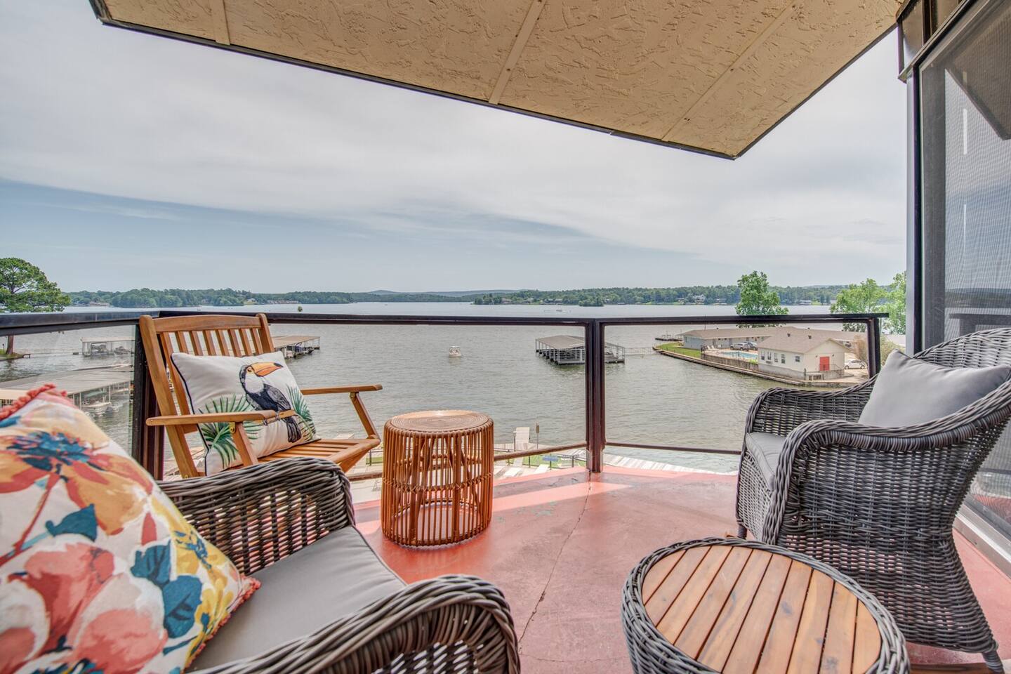 A balcony with wicker furniture and a view of the water.