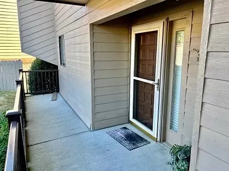 The front door of a house with a sliding glass door and a balcony.