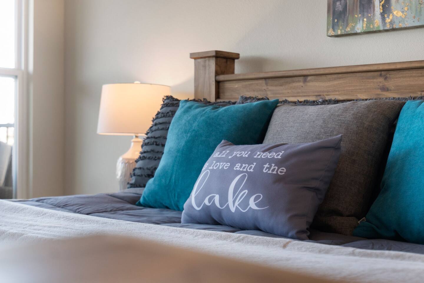 A bed with a pillow that says `` all you need is love and the lake ''.