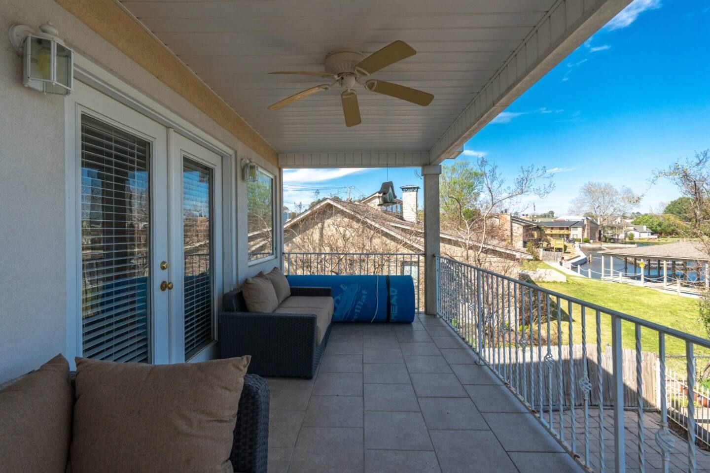 A porch with a couch and a ceiling fan.
