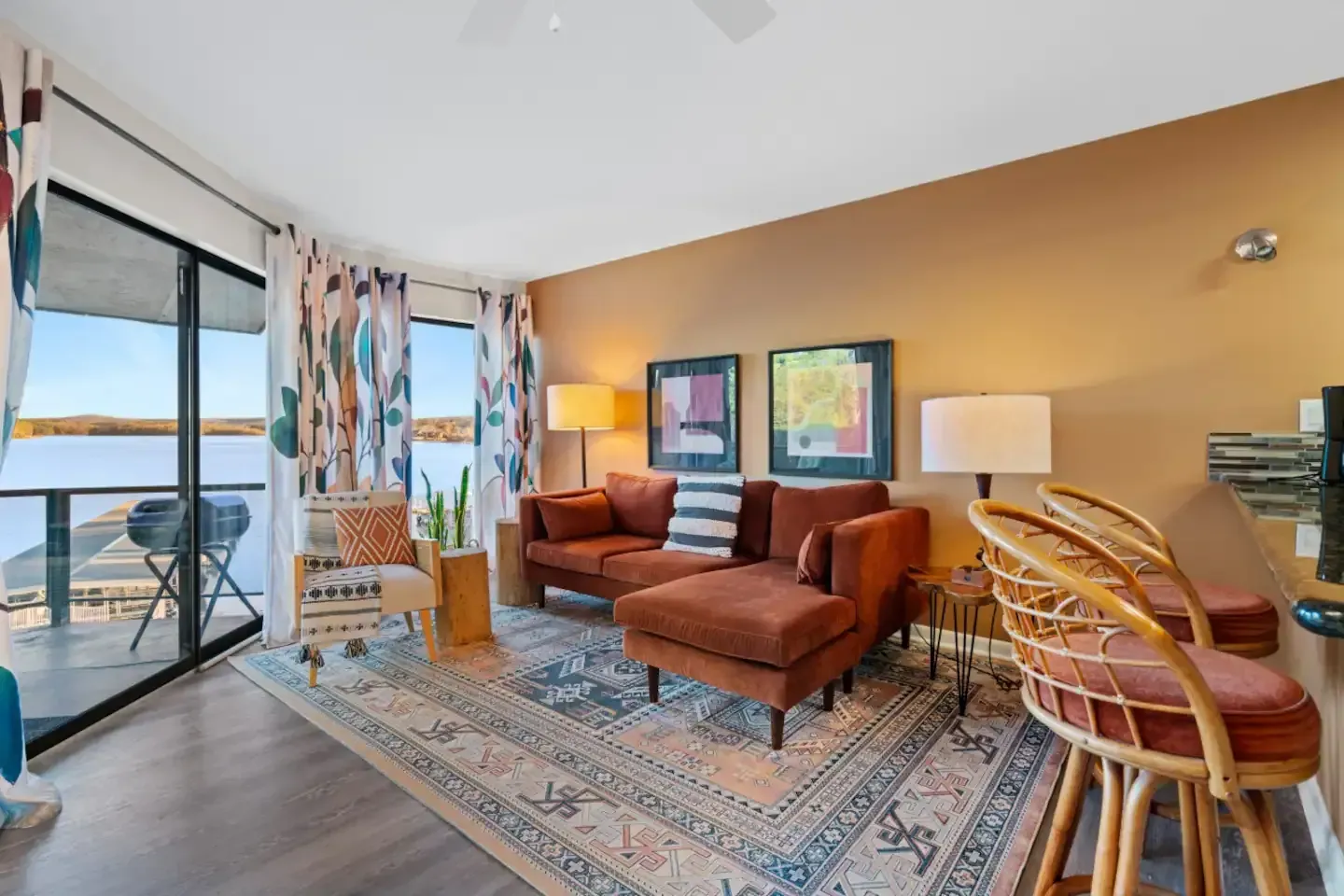 A living room with a couch , chairs , lamps and a rug.