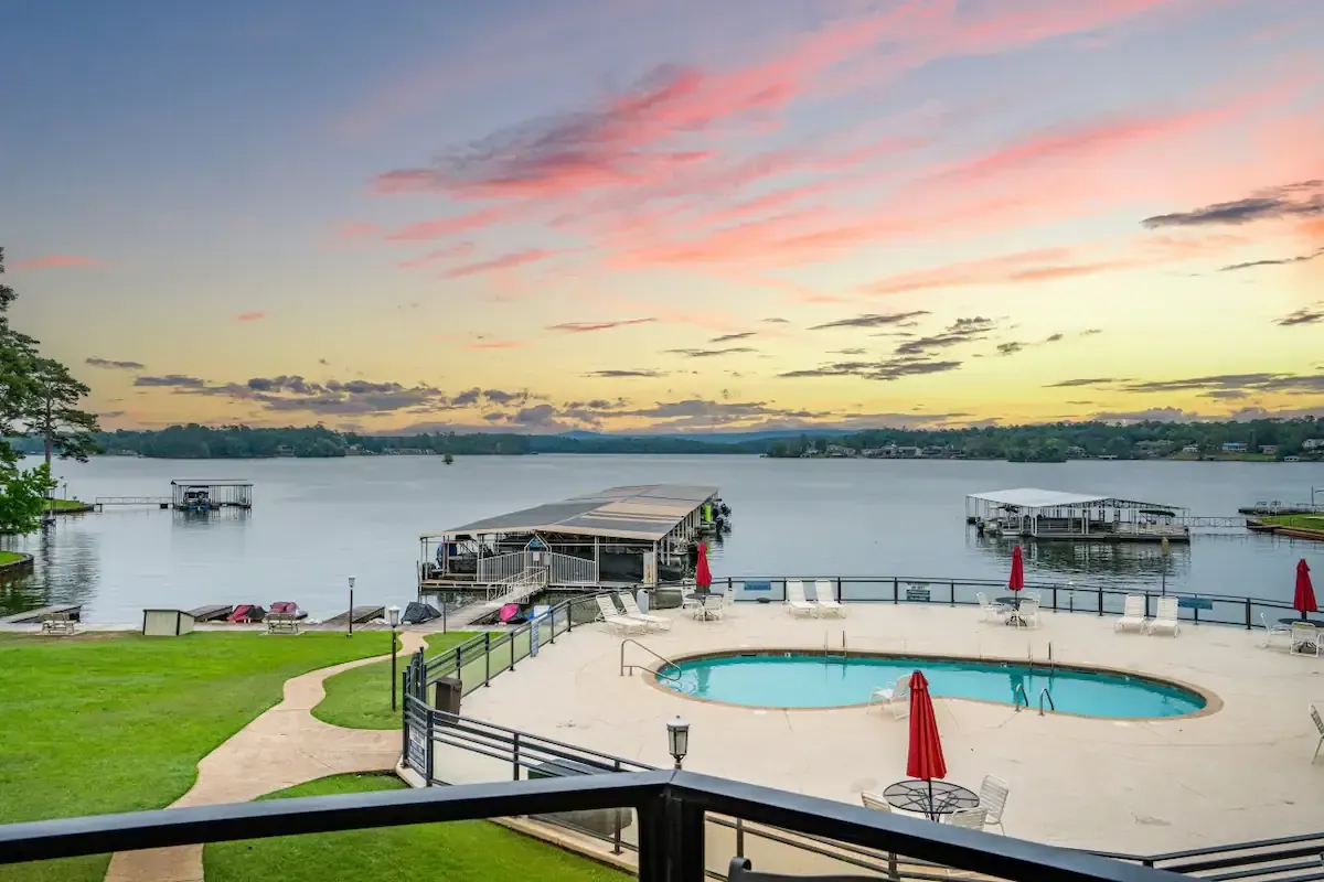 A view of a lake from a balcony with a swimming pool.
