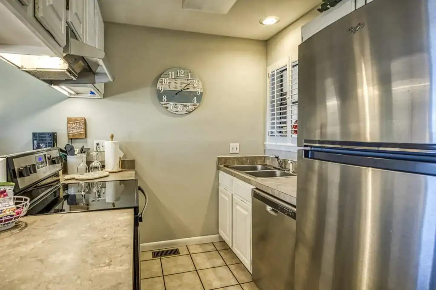 A kitchen with a stainless steel refrigerator , sink , stove and dishwasher.