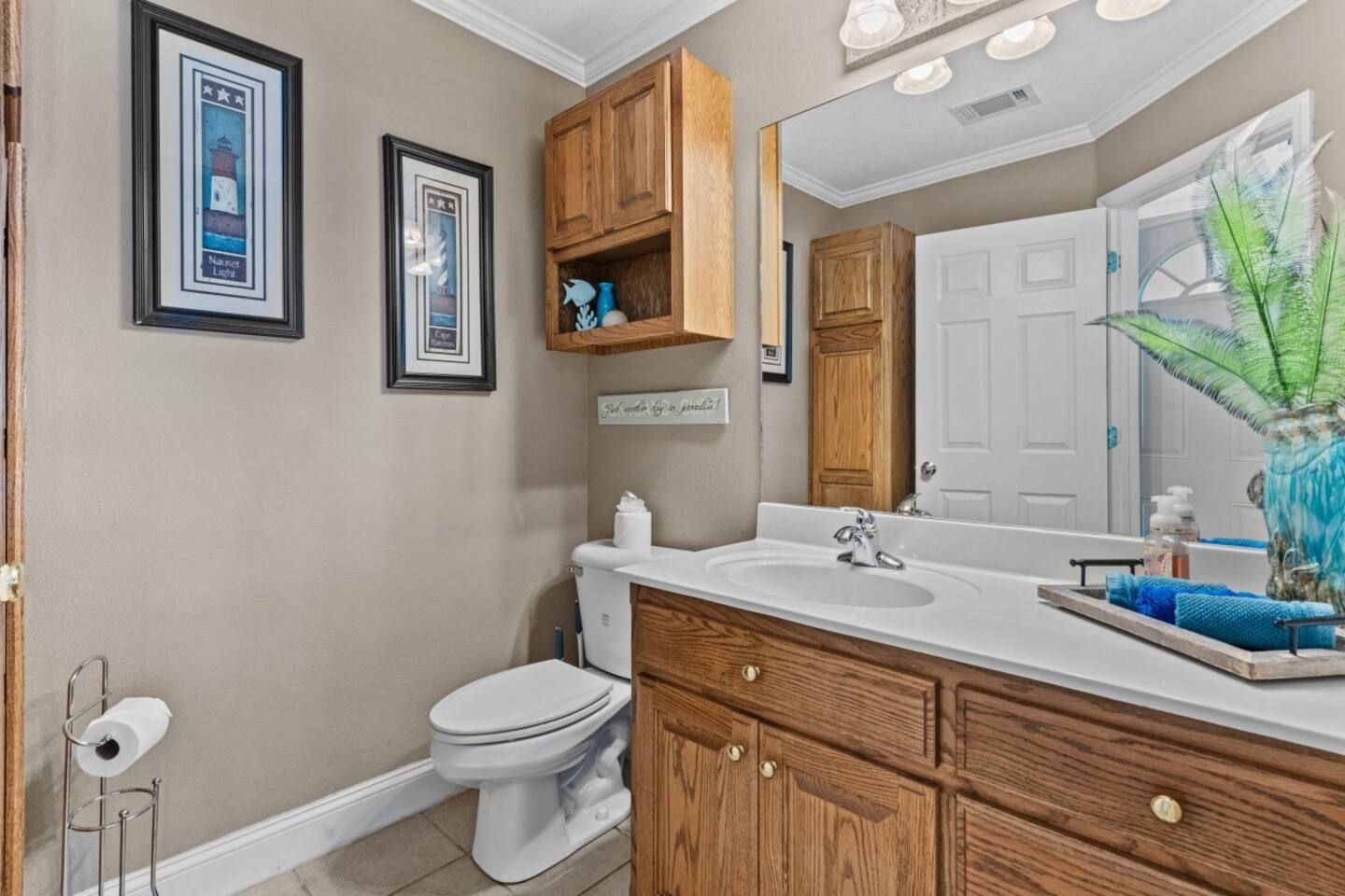 A bathroom with a toilet , sink and mirror.