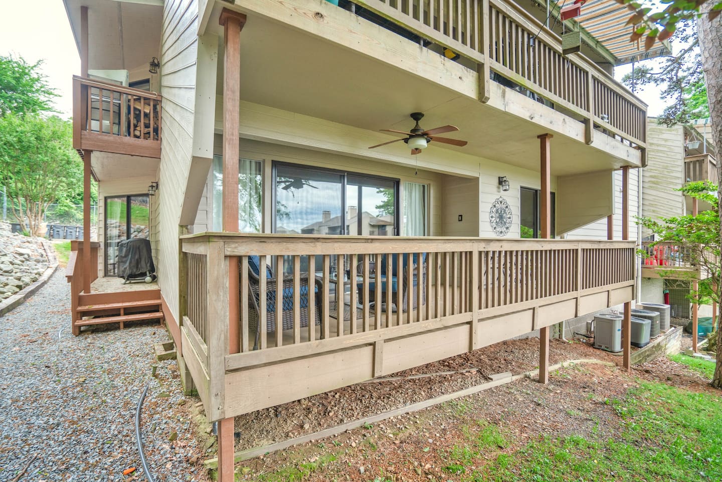 A house with a large deck and a ceiling fan.