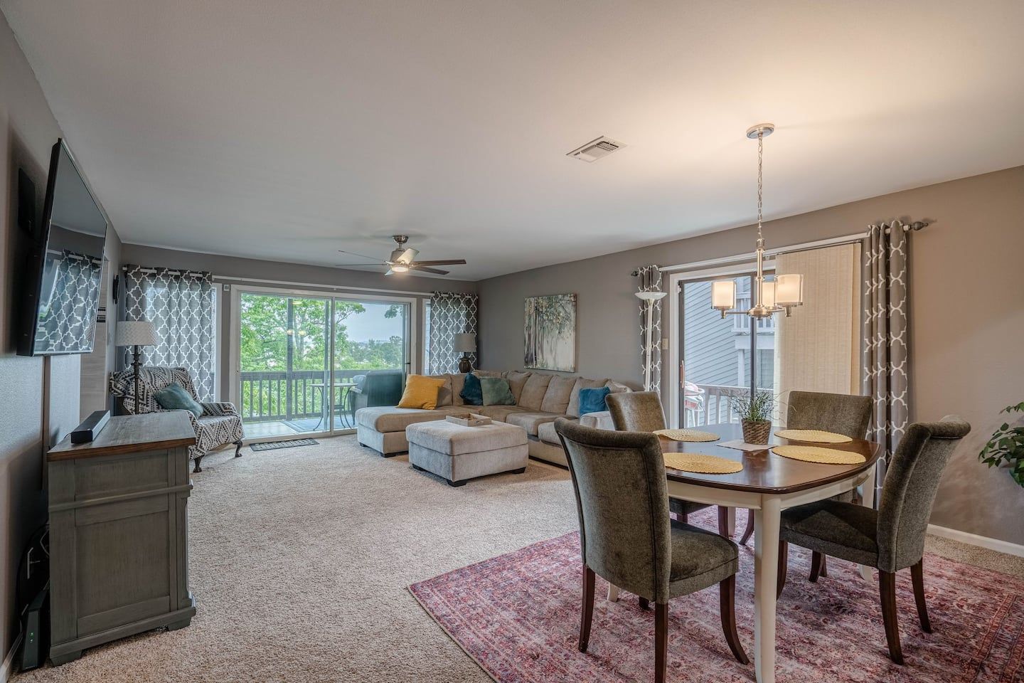 A living room and dining room in a house with a table and chairs.
