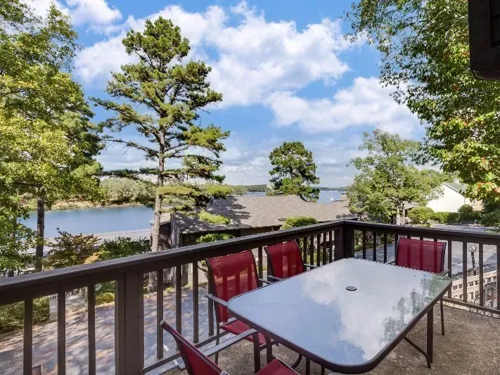 A balcony with a table and chairs overlooking a lake