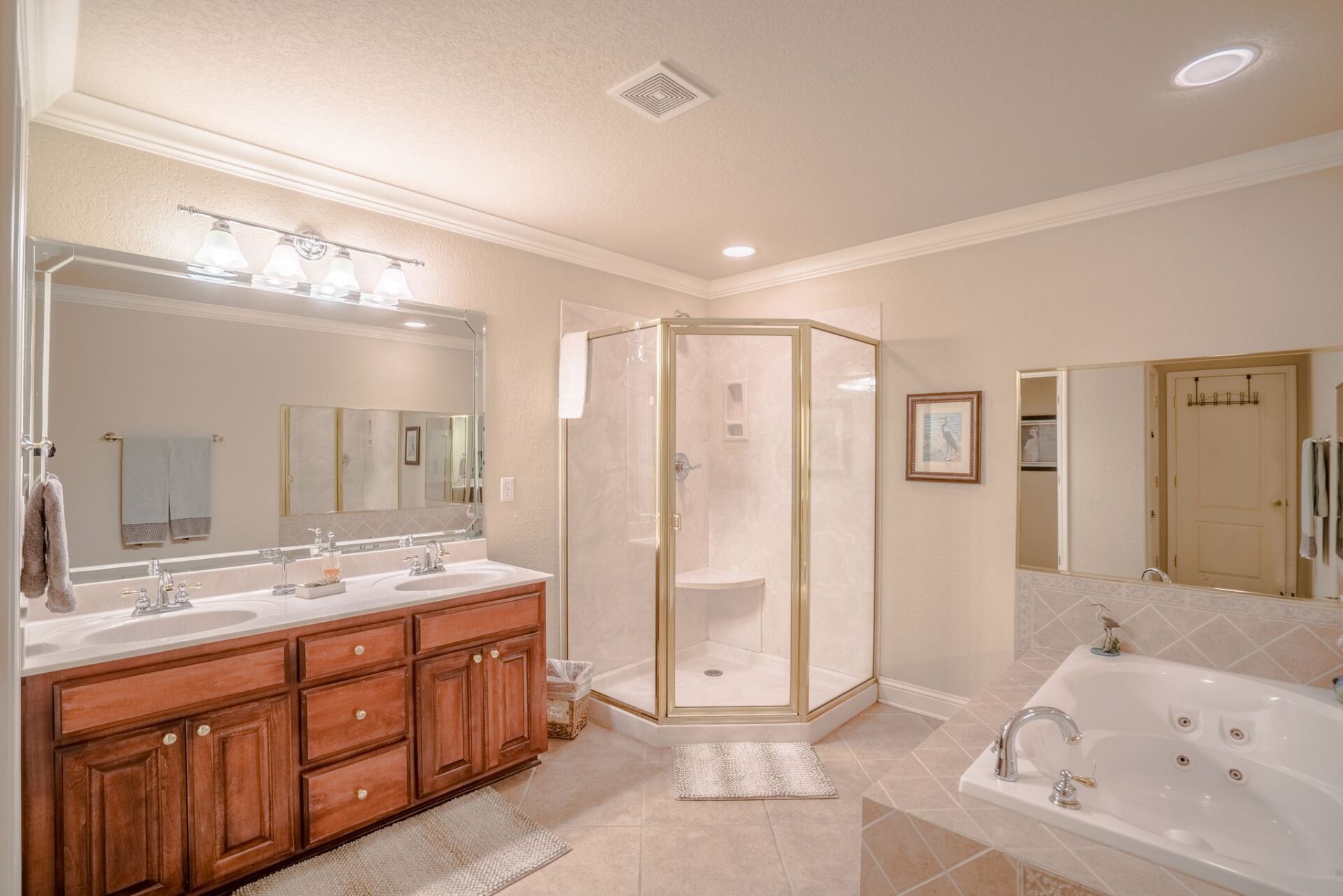A bathroom with two sinks , a tub , and a walk in shower.