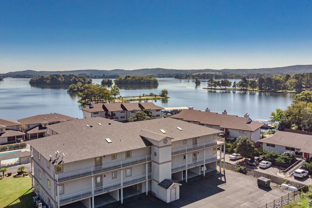 An aerial view of a large apartment building next to a lake.