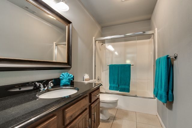 A bathroom with a sink , toilet , shower and mirror