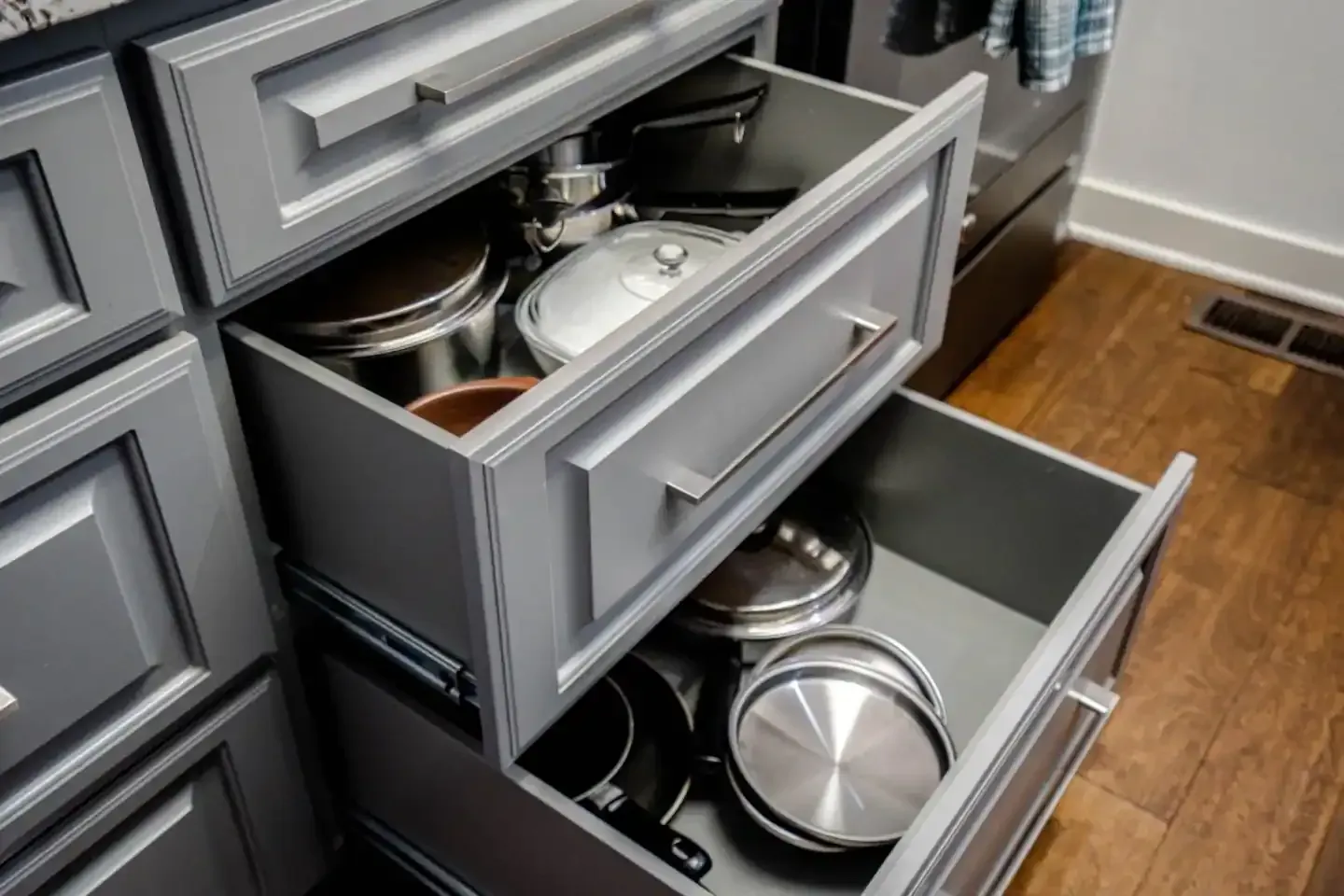A kitchen drawer filled with pots and pans.