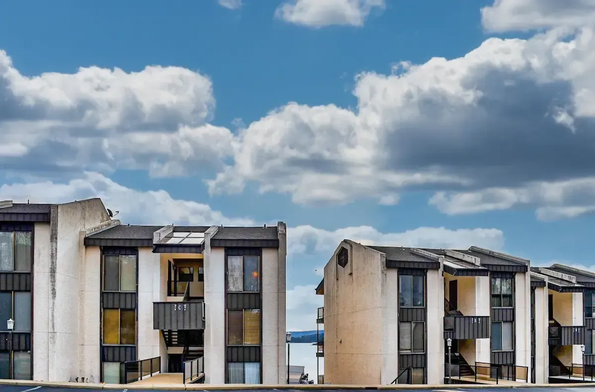 A row of apartment buildings against a cloudy blue sky
