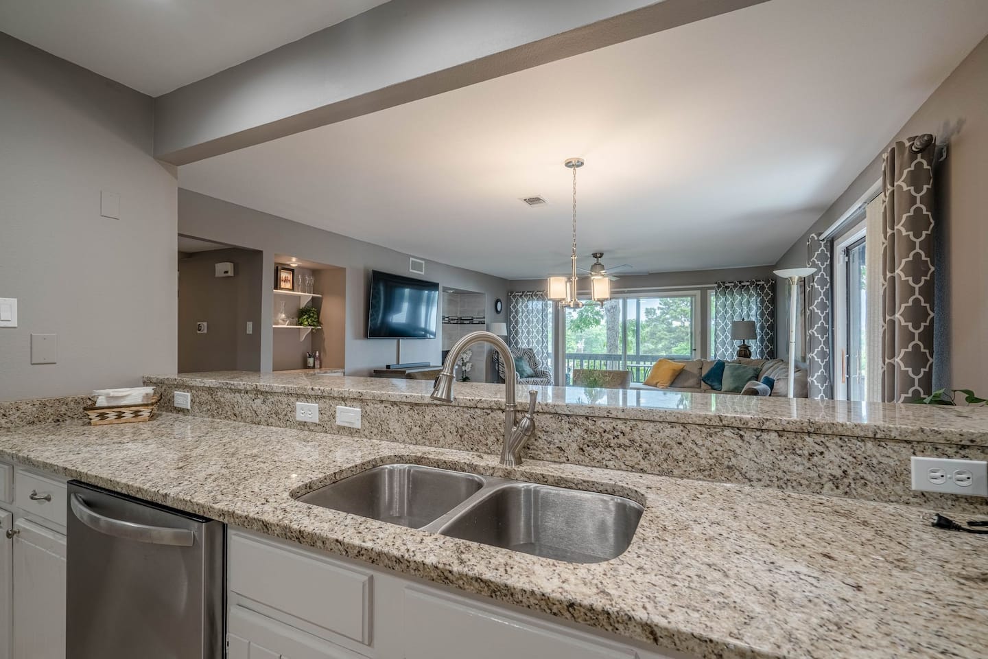 A kitchen with granite counter tops and two sinks.