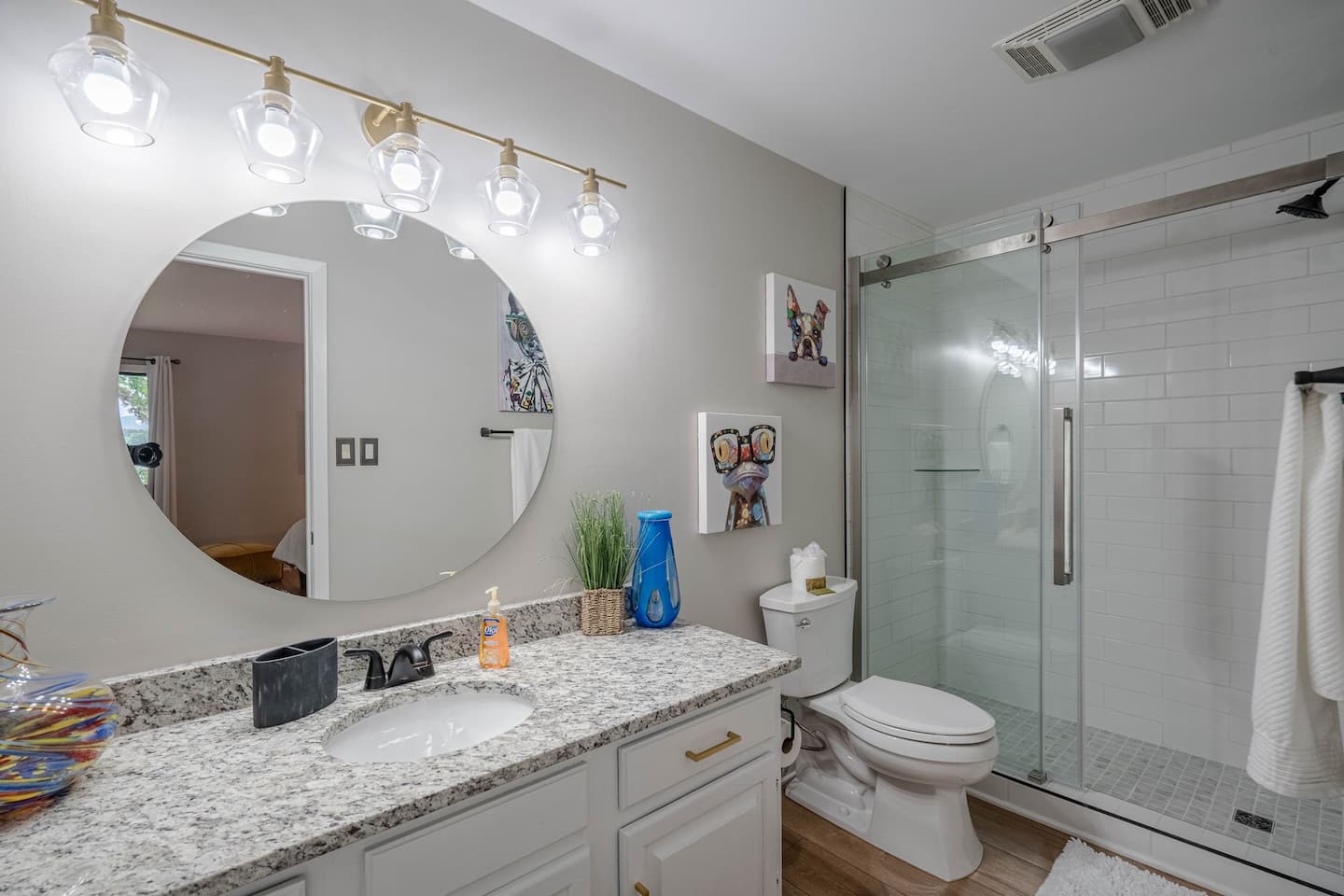A bathroom with a toilet , sink , mirror and shower.