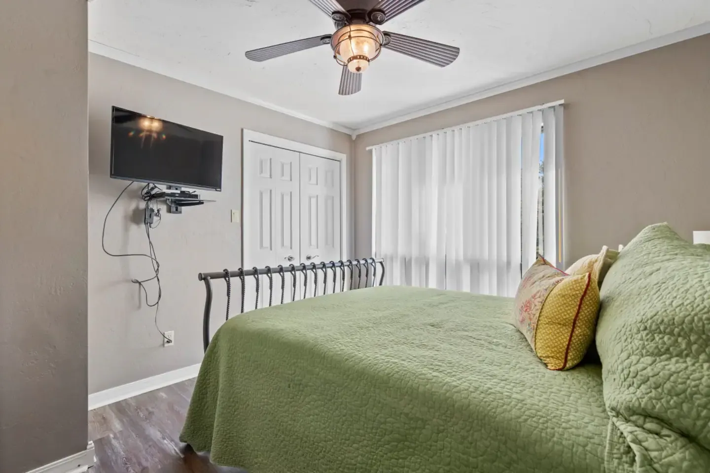 A bedroom with a bed , television and ceiling fan.