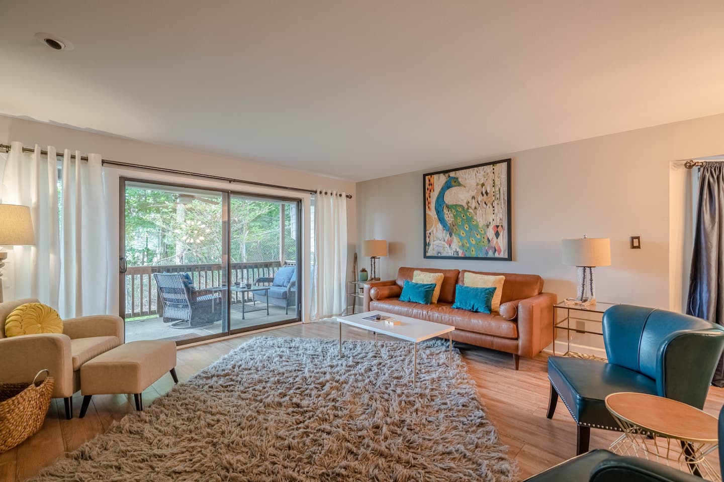 A living room with a couch , chairs , and a rug.