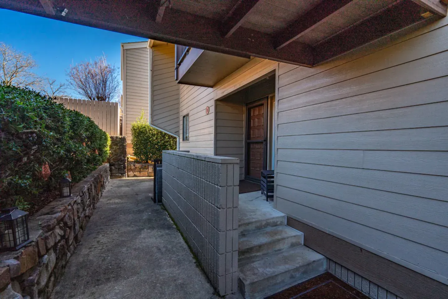A narrow walkway leading to the front door of a house.