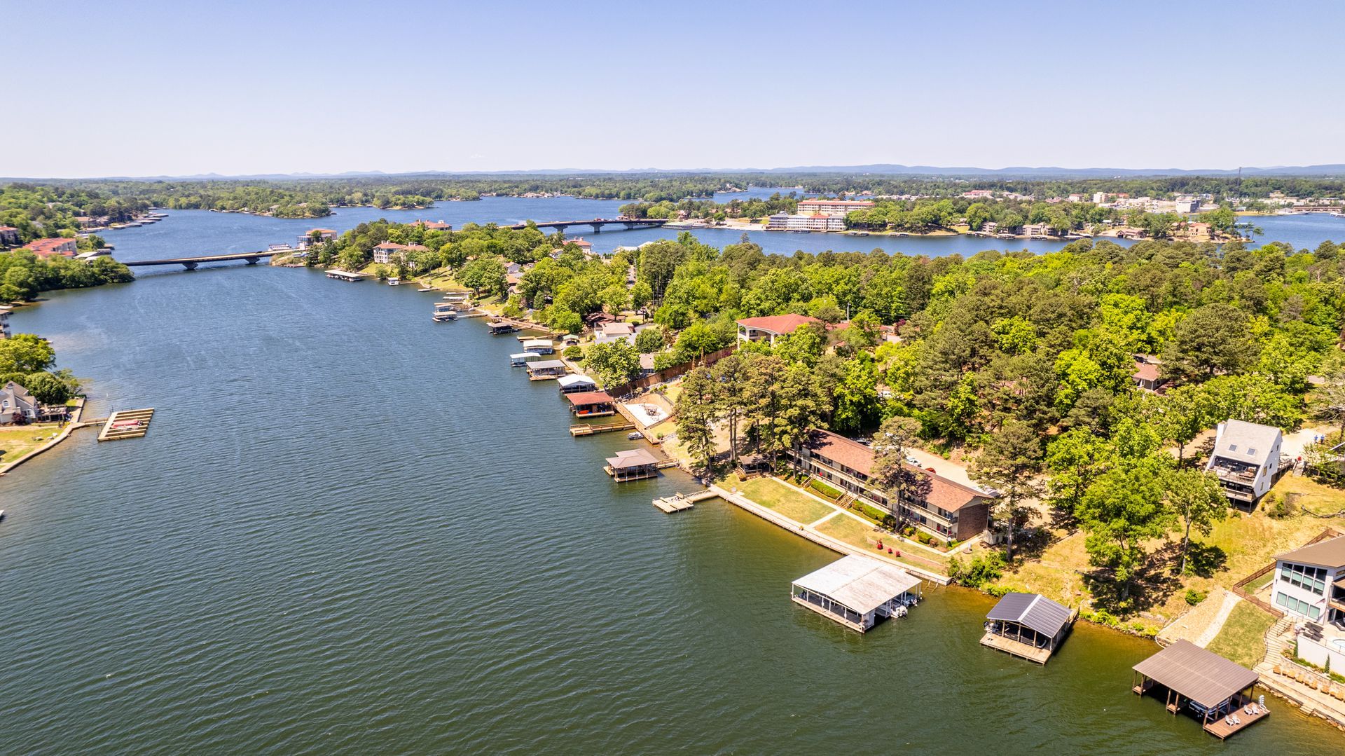 An aerial view of a lake surrounded by trees and houses.