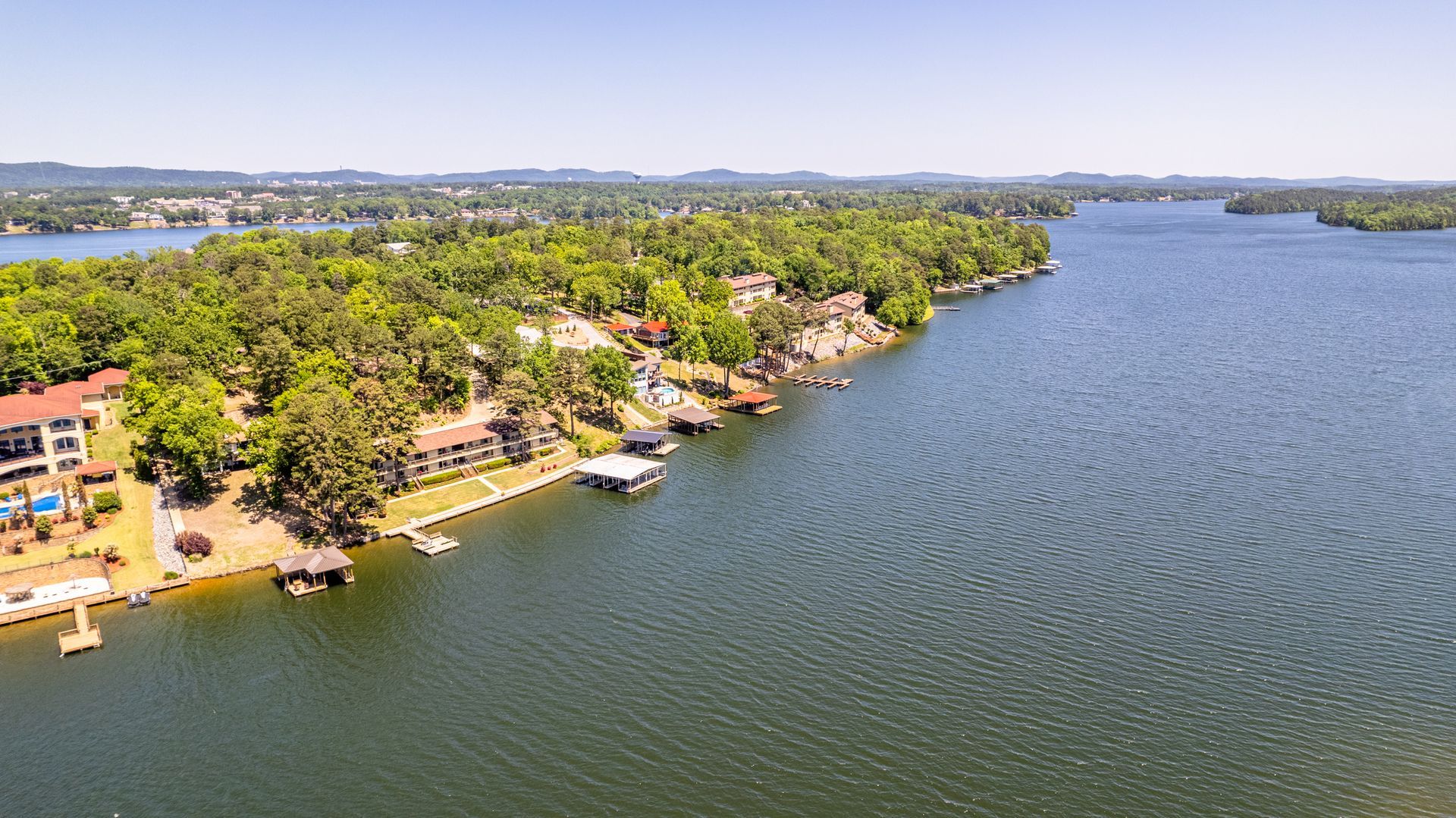 An aerial view of a lake surrounded by trees and houses.
