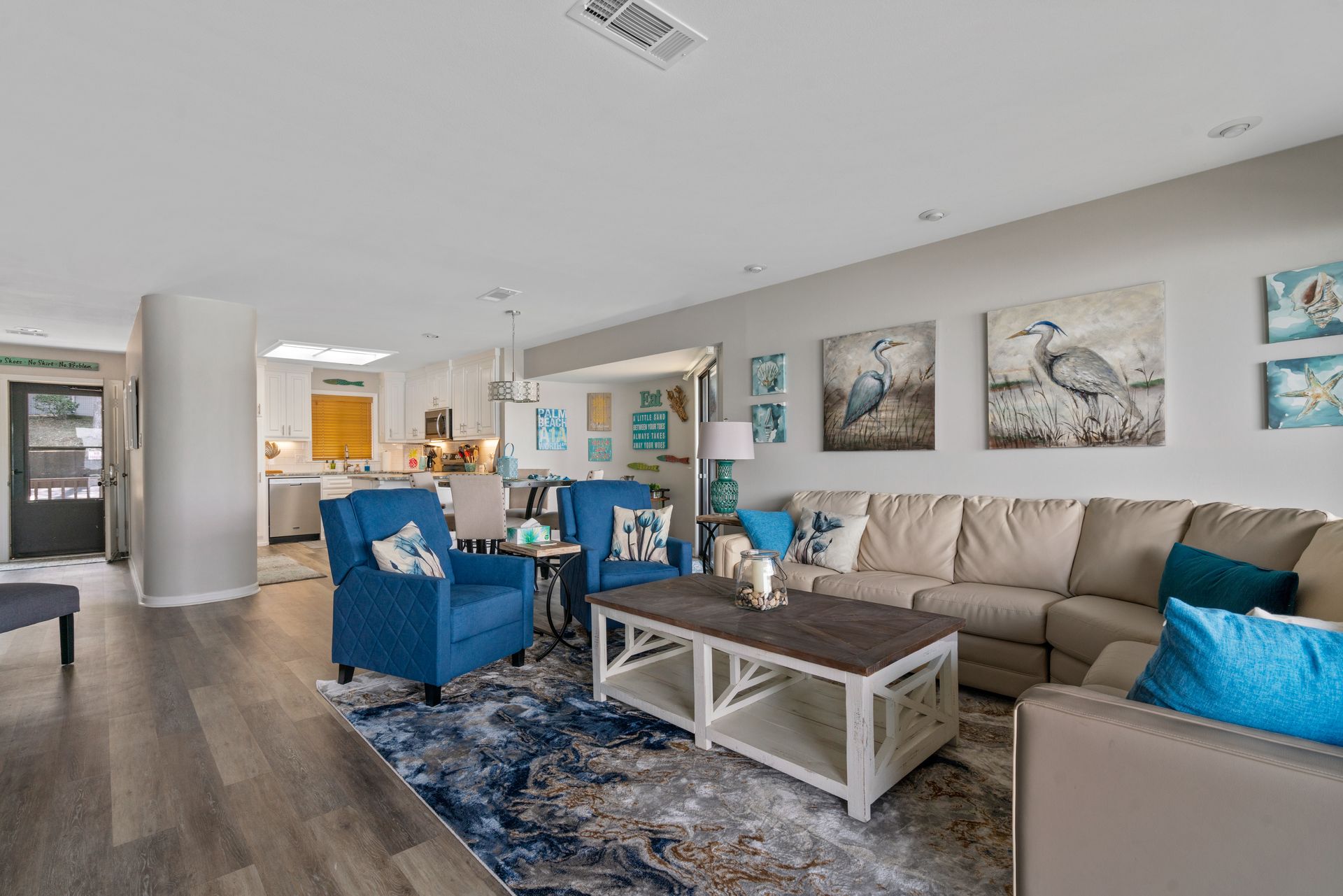 A living room with a couch , chairs , and a coffee table.