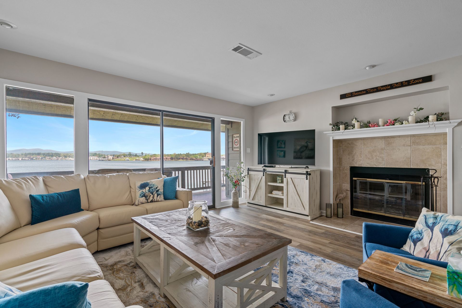 A living room filled with furniture and a fireplace with a view of the ocean.