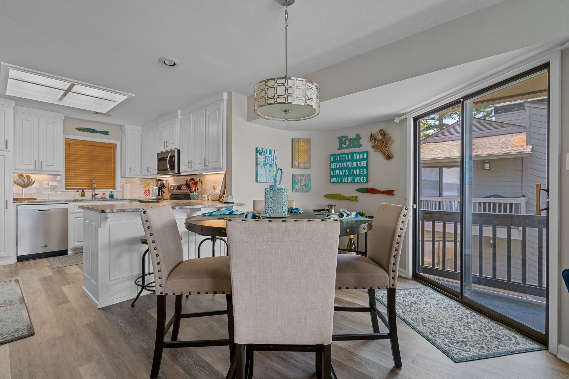 A dining room with a table and chairs and a sliding glass door leading to a balcony.