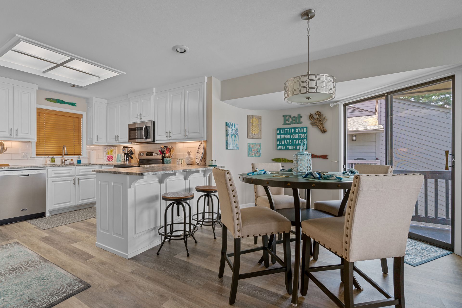 A kitchen and dining room in a house with a table and chairs.