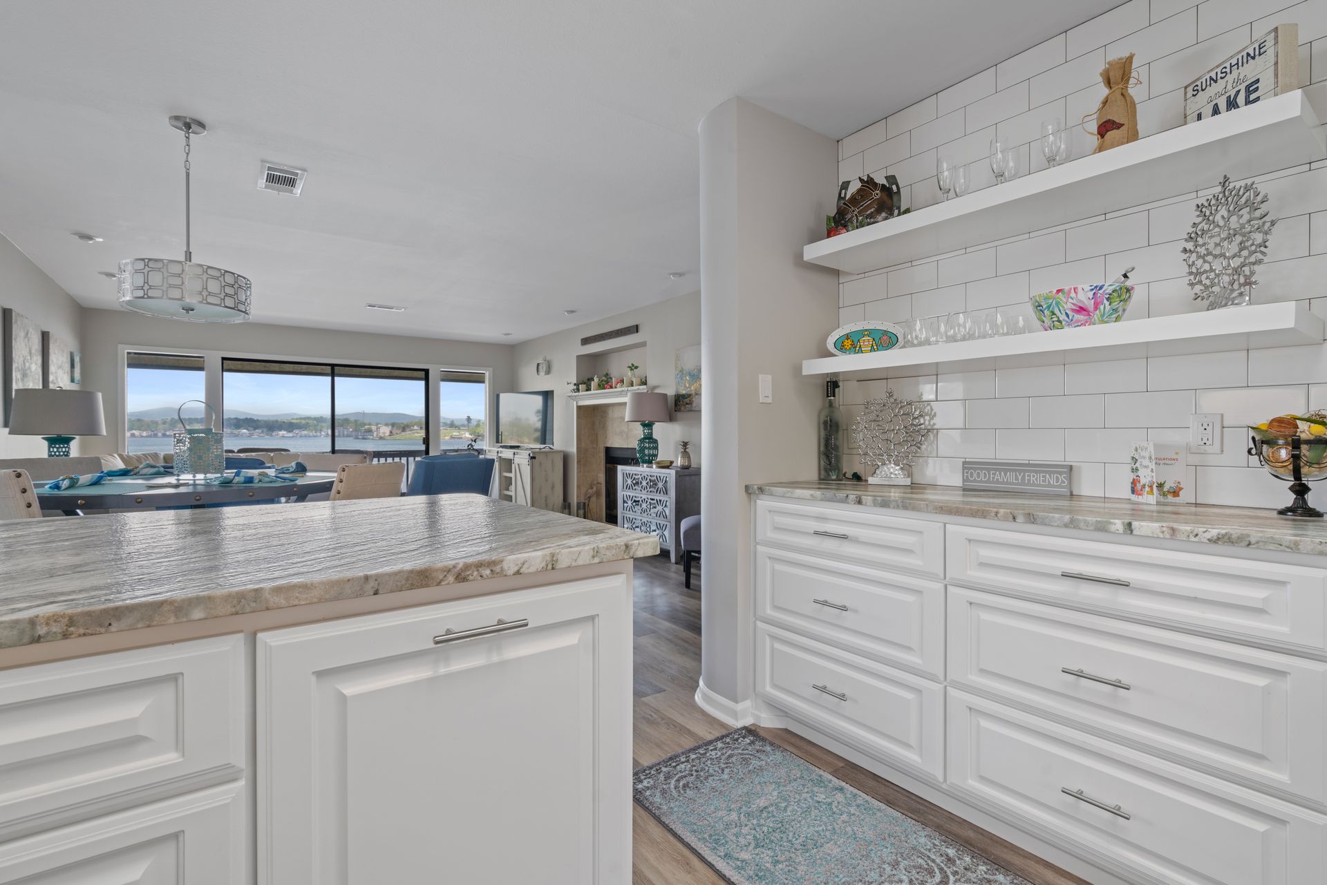 A kitchen with white cabinets and granite counter tops.