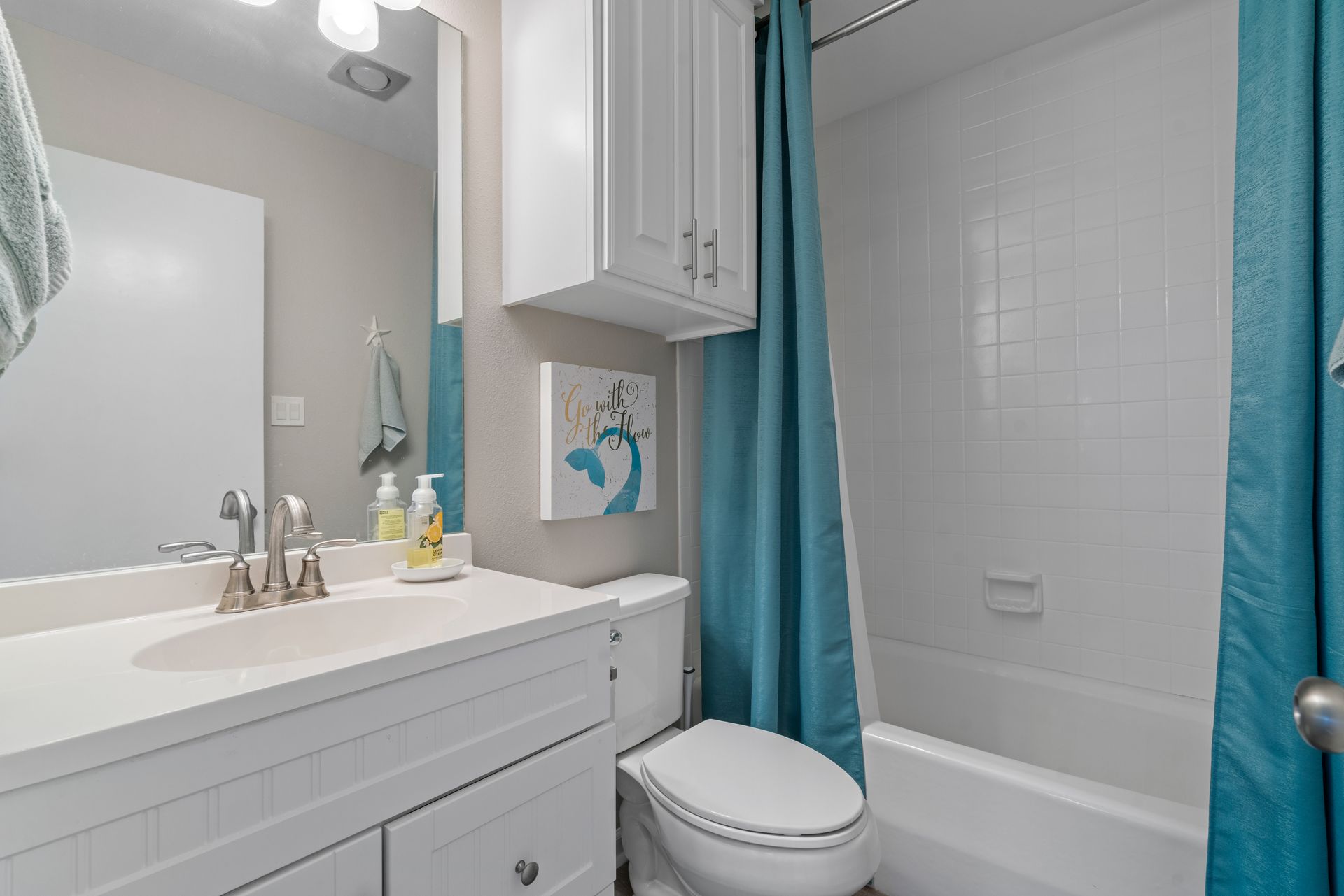 A bathroom with a toilet , sink , shower and tub.