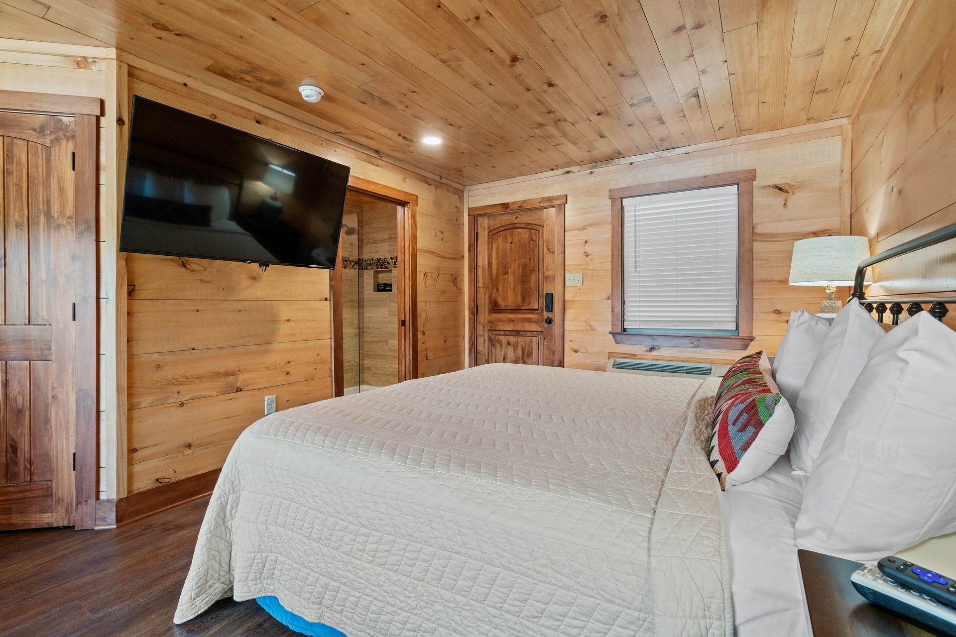 A bedroom in a cabin with a king size bed and a flat screen tv.